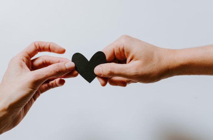 two person holding papercut heart