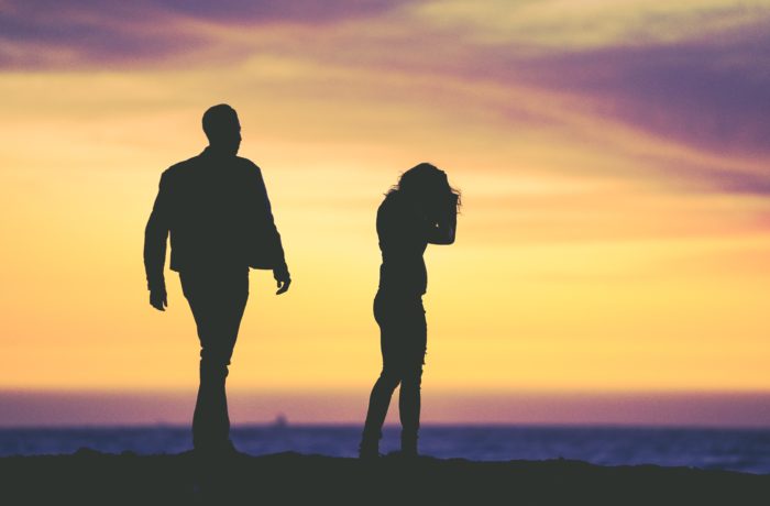 silhouette of man and woman under yellow sky