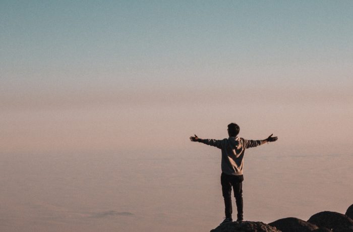 man standing beside cliff