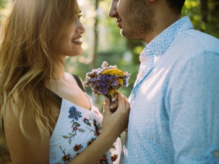 man and woman facing each other while holding flowers