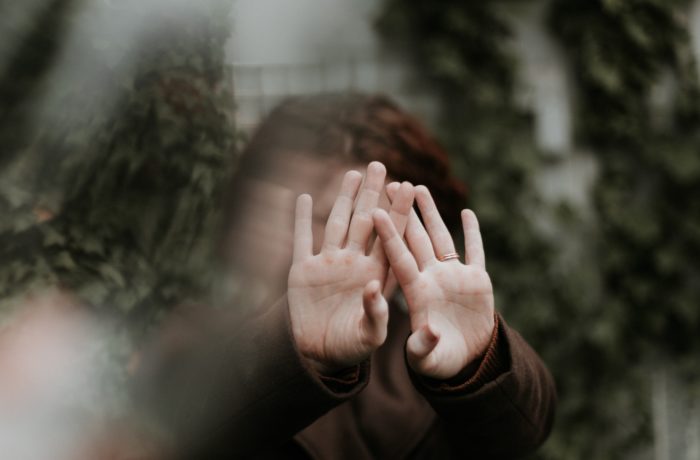 person in brown long sleeve shirt covering face with hand