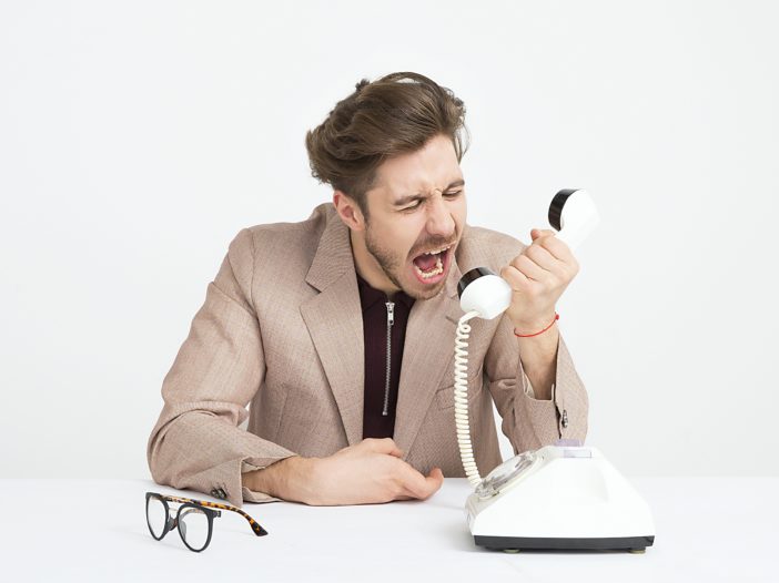 man holding telephone screaming