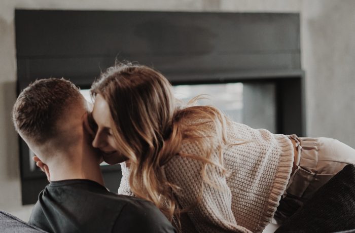 man and woman kissing on the window