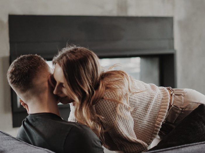 man and woman kissing on the window