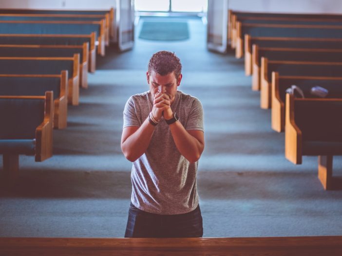 man standing near altar praying