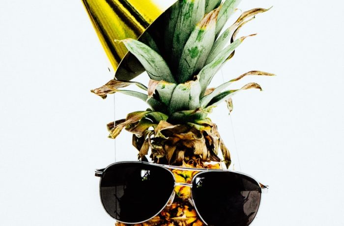 ripe pineapple with yellow cone and sunglasses