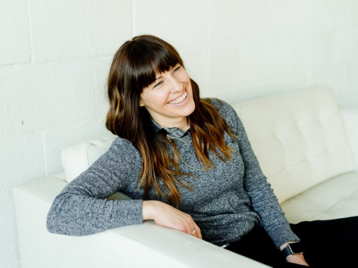 woman in gray sweater sitting on white chair