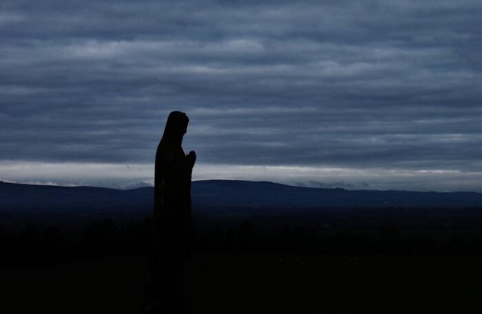 silhouette of person under cloudy sky